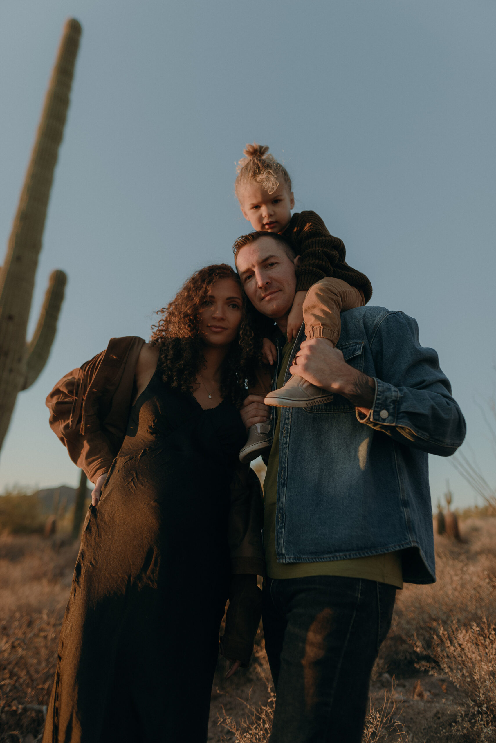 Baby bump photos surrounded by tall cacti